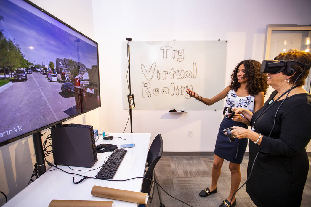 Ebonique Diaz with Terbine helps demonstrate a Google Earth virtual reality system to Lynn Smit ...