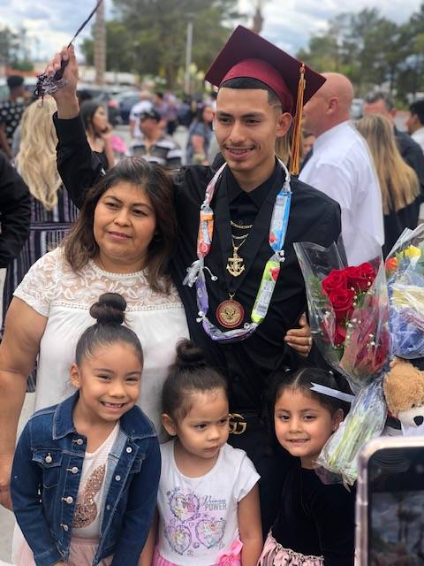 Brian Lopez, 18, poses with family members the day of his high school graduation in June 2019. ...