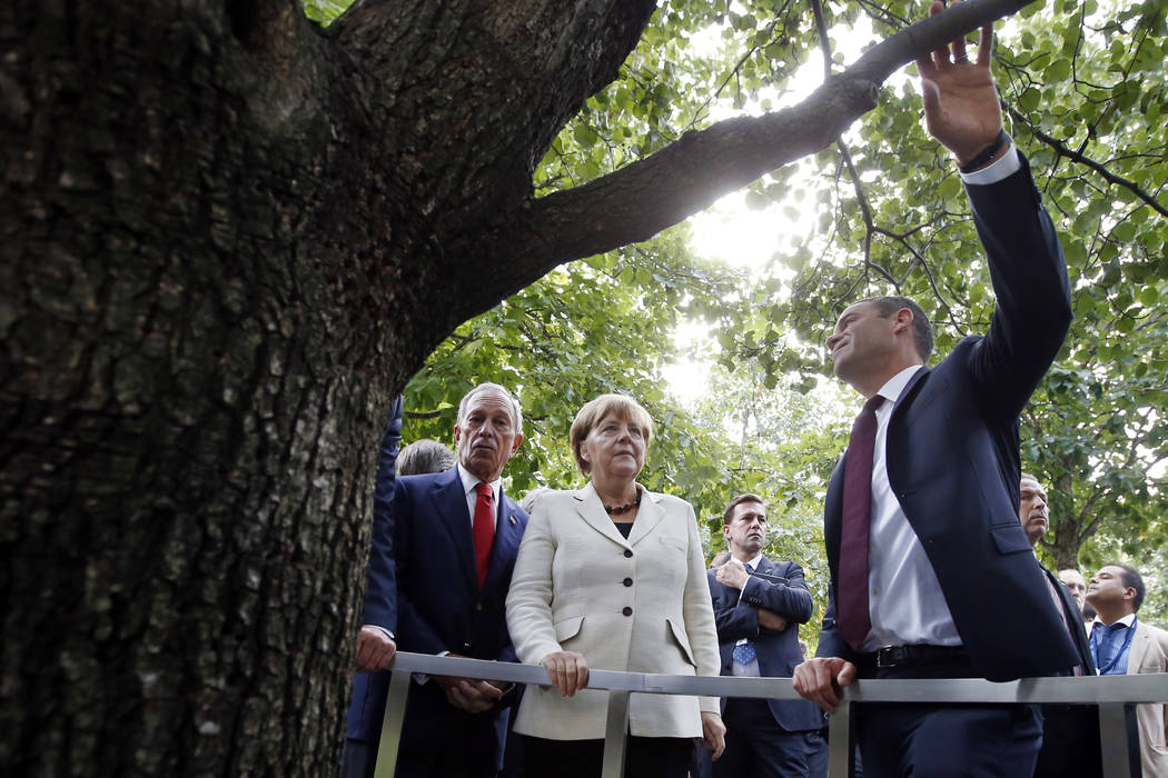 German Chancellor Angela Merkel takes a closer look at the Survivor Tree after placing a wreath ...