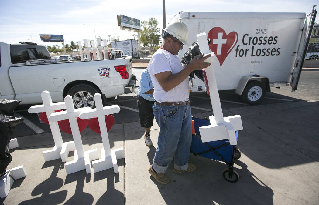 Greg Zanis, of Aurora, Ill., unloads several of the 58 crosses he placed near the Welcome to Fa ...