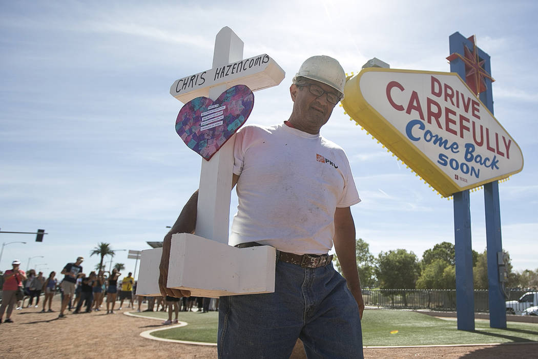 Greg Zanis, of Aurora, Ill., carries one of 58 crosses he placed near the Welcome to Fabulous L ...
