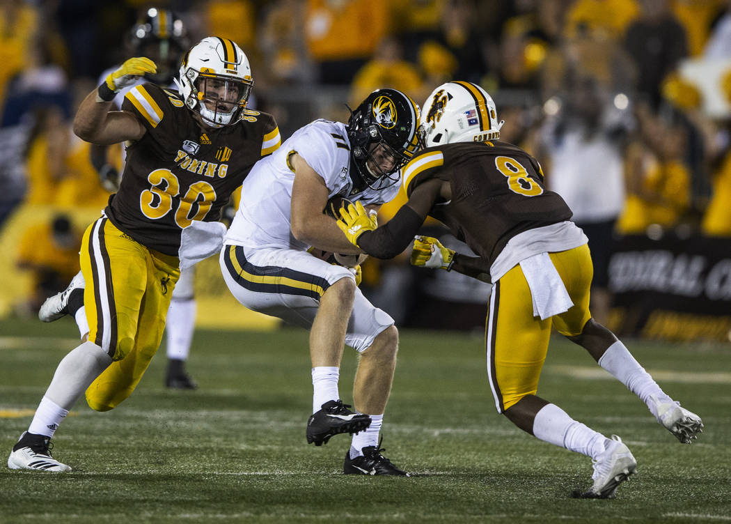 Missouri receiver Barrett Banister (11) is tackled by Wyoming defenders Logan Wilson (30) and R ...