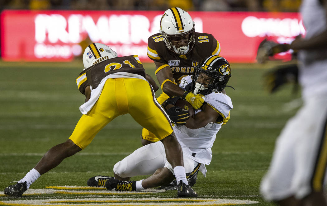 Missouri receiver Jonathon Johnson is tackled by Wyoming defenders C.J. Coldon (21) and Keyon B ...