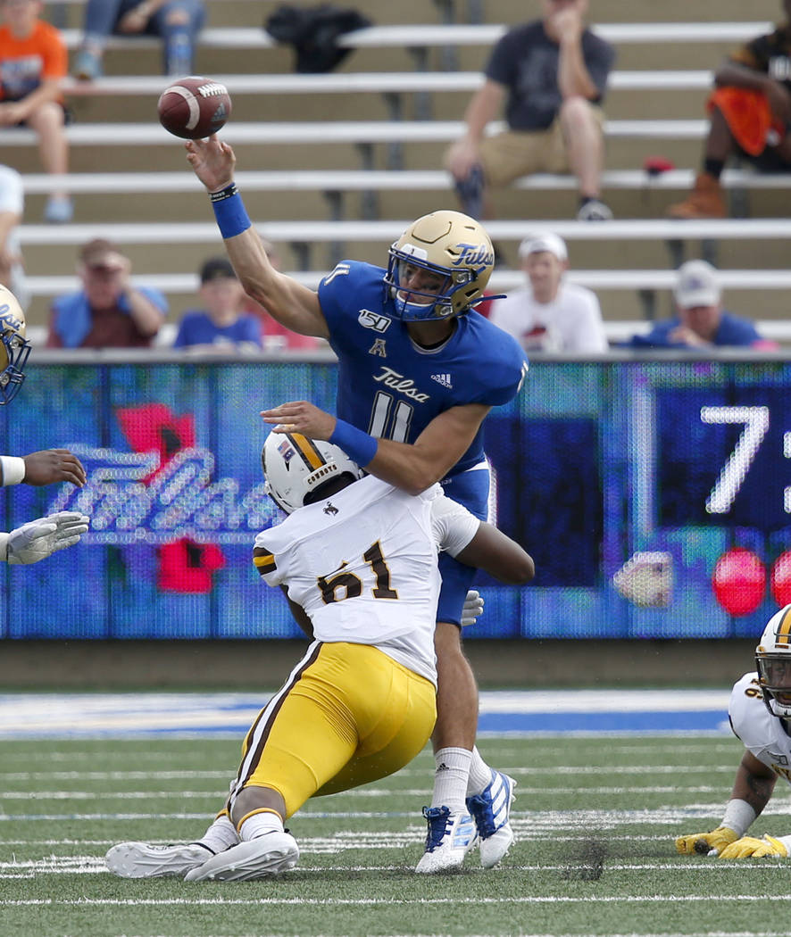 Tulsa's Zach Smith, right, is pressured by Wyoming's Solomon Bryd, left, during an NCAA colleg ...