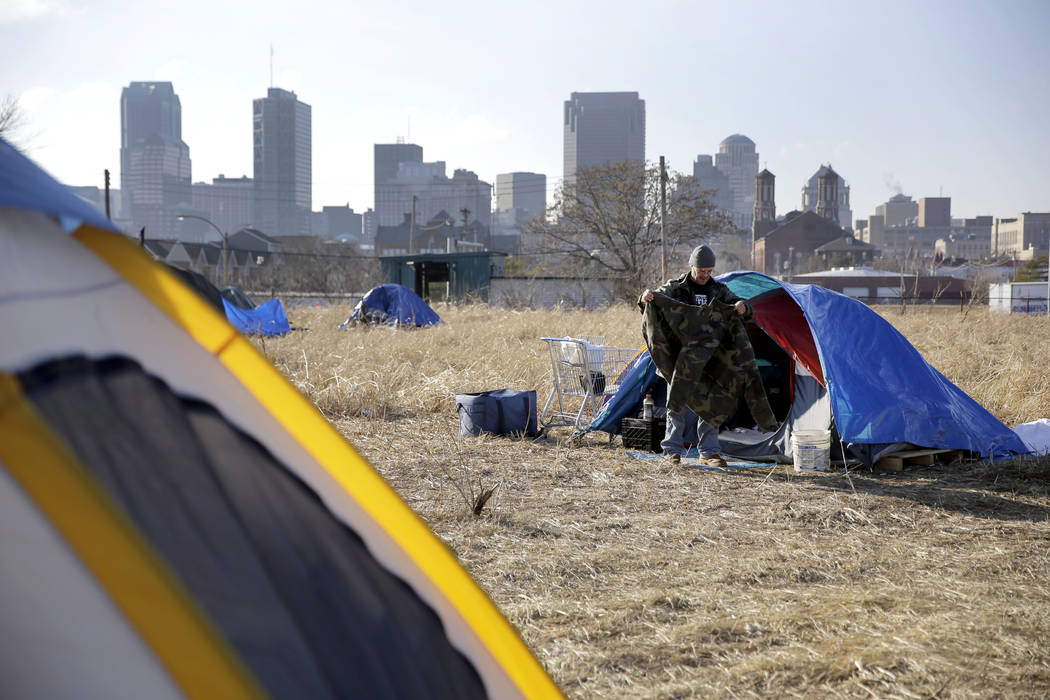 In a Tuesday, Jan. 27, 2015, file photo, Terry, cleans out his tent at a large homeless encampm ...
