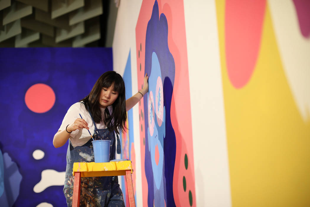 Artist Amanda Phingbodhipakkiya touches up a mural at her show "Connective Tissue" at ...