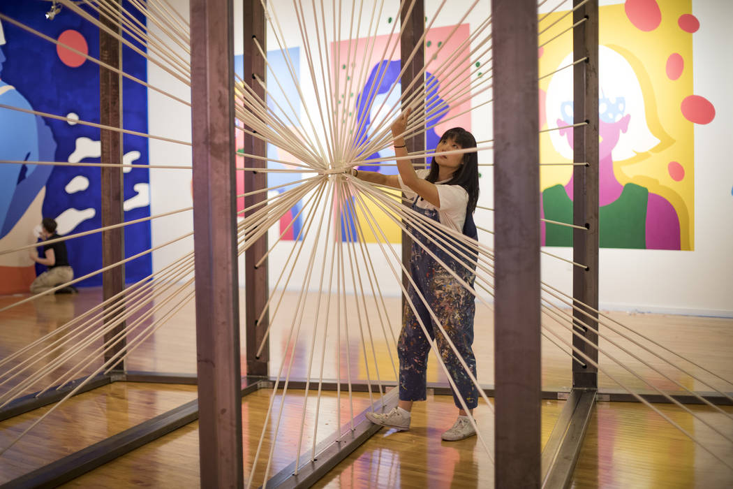 Artist Amanda Phingbodhipakkiya sets up the installation "There Are No Particles Only Fiel ...