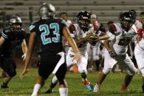 Las Vegas High's quarterback Ja'shawn Scroggins, second right, runs with the ball during the fi ...