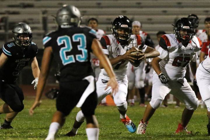 Las Vegas High's quarterback Ja'shawn Scroggins, second right, runs with the ball during the fi ...