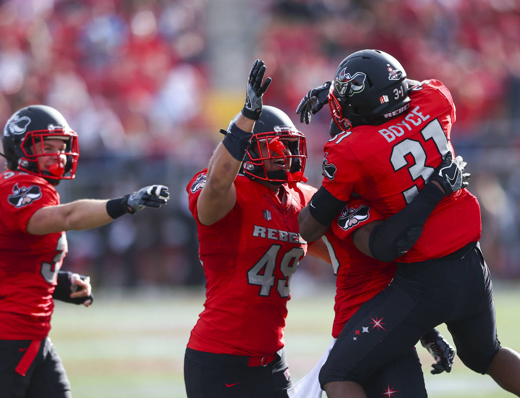 UNLV players celebrate after gaining possession of the ball following a fumble by Wyoming durin ...