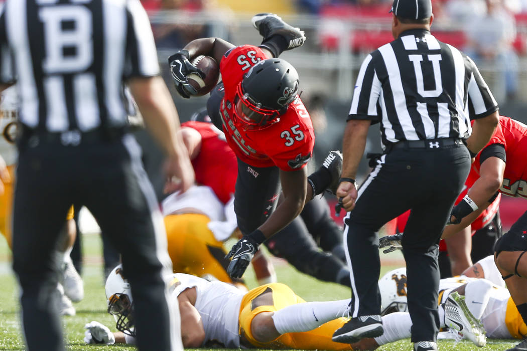 UNLV running back Xzaviar Campbell (35) is tripped up during a football game against Wyoming at ...
