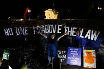 Protesters with Kremlin Annex with a light sign that reads "NO ONE IS ABOVE THE LAW" ...