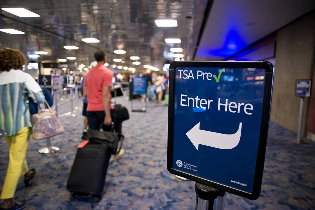 Passengers walk toward the TSA PreCheck security line at McCarran International Airport in Las ...