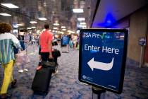 Passengers walk toward the TSA PreCheck security line at McCarran International Airport in Las ...