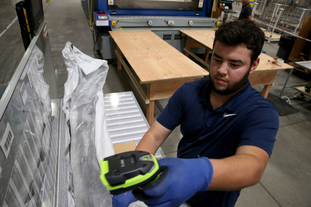 Jose Magdaleno makes a custom box by scanning the dimensions of a car part at the new CarParts. ...