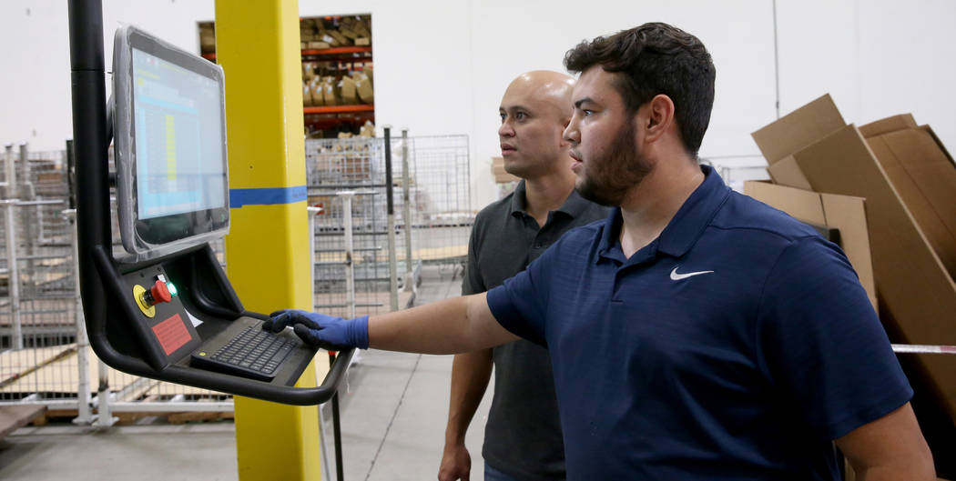 Jose Magdaleno, right, and Joseph Divino make a custom box after scanning the dimensions of a c ...