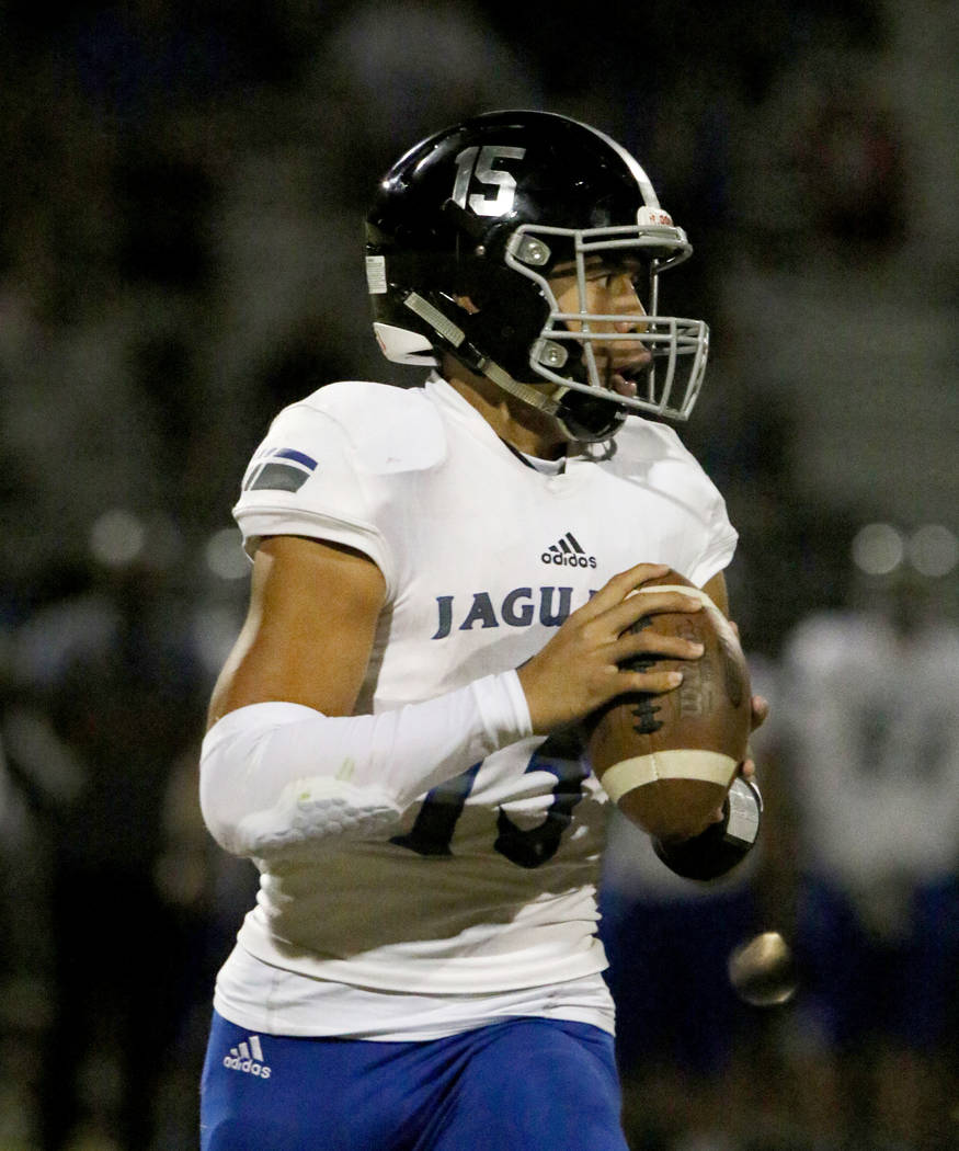 Desert Pines High quarterback Rjay Tagataese (15) looks for an opening as he runs with the ball ...