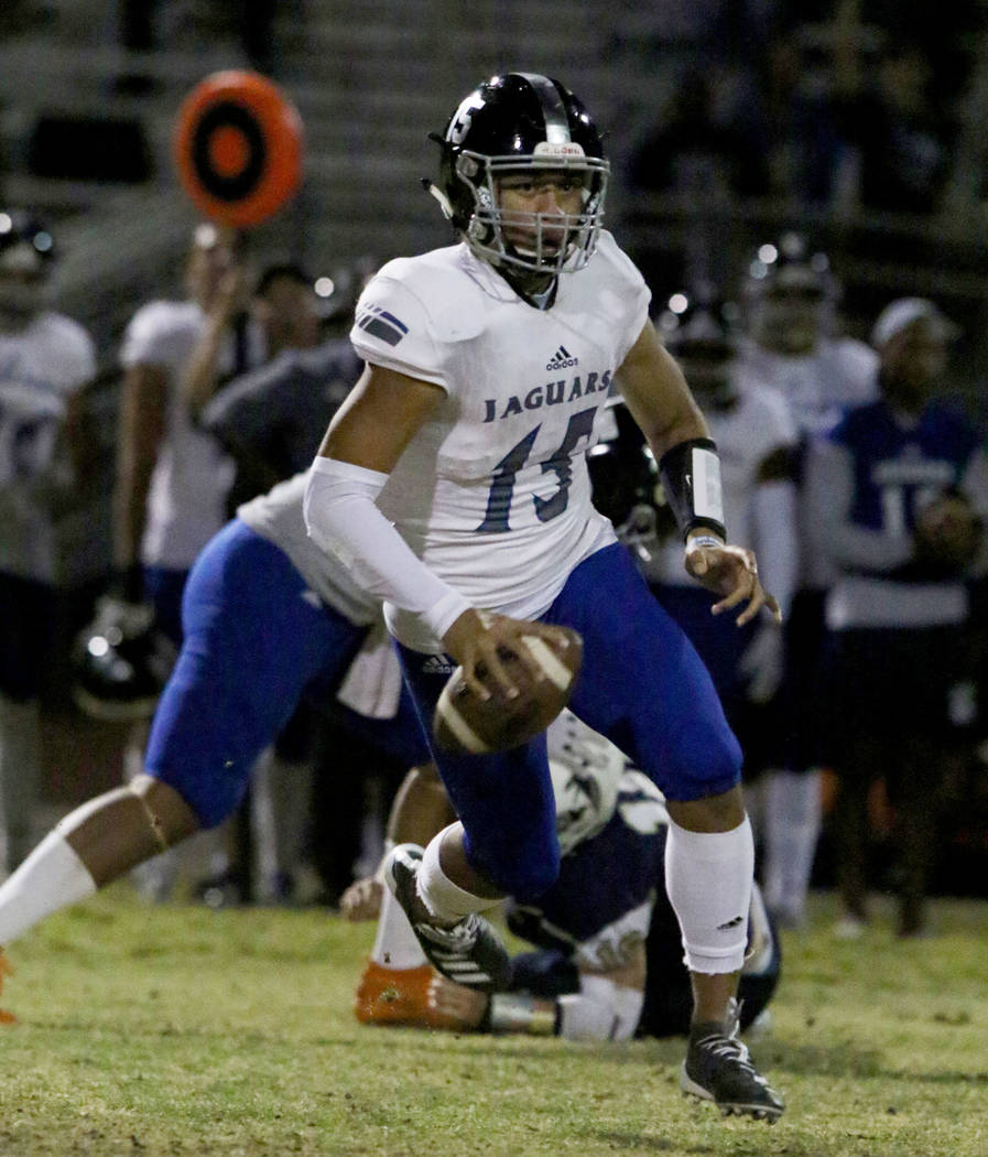 Desert Pines High quarterback Rjay Tagataese (15) looks for an opening as he runs with the ball ...