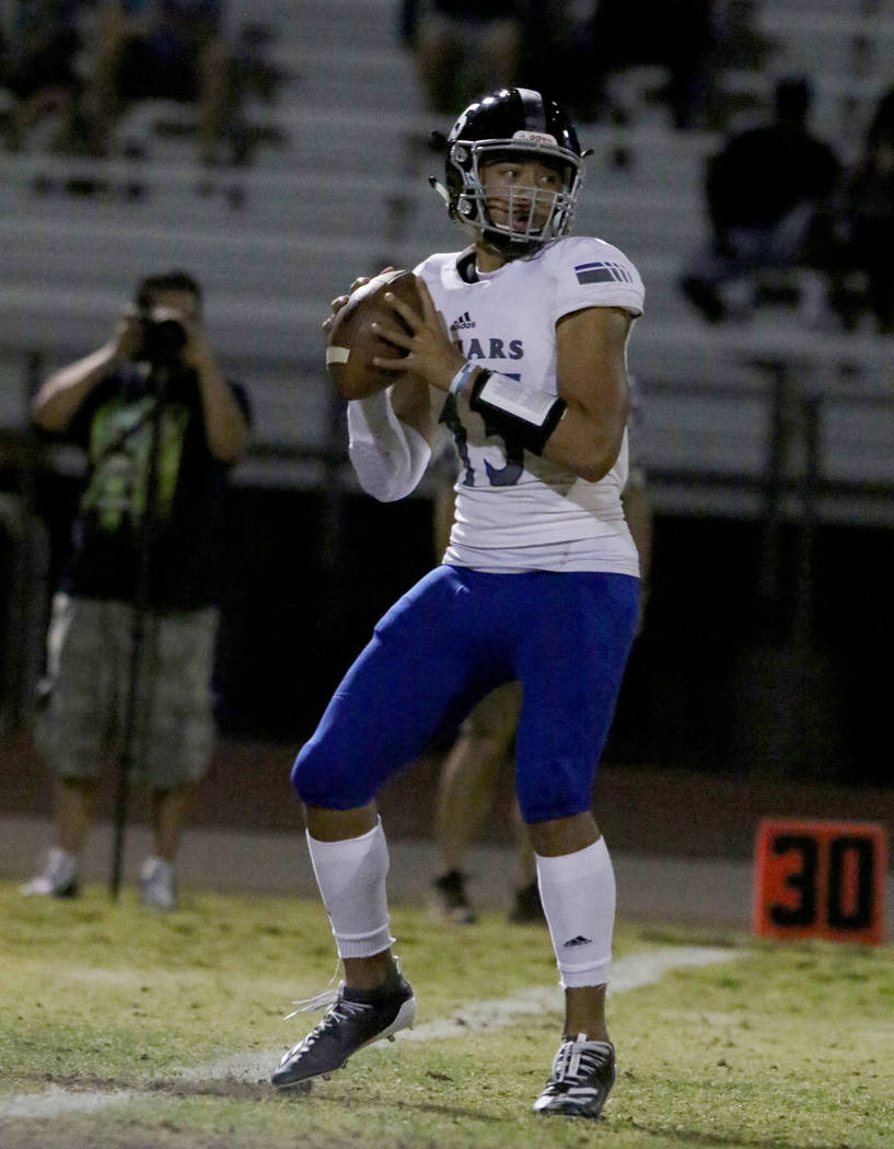 Desert Pines High quarterback Rjay Tagataese (15) looks for an opening as he prepares to throw ...