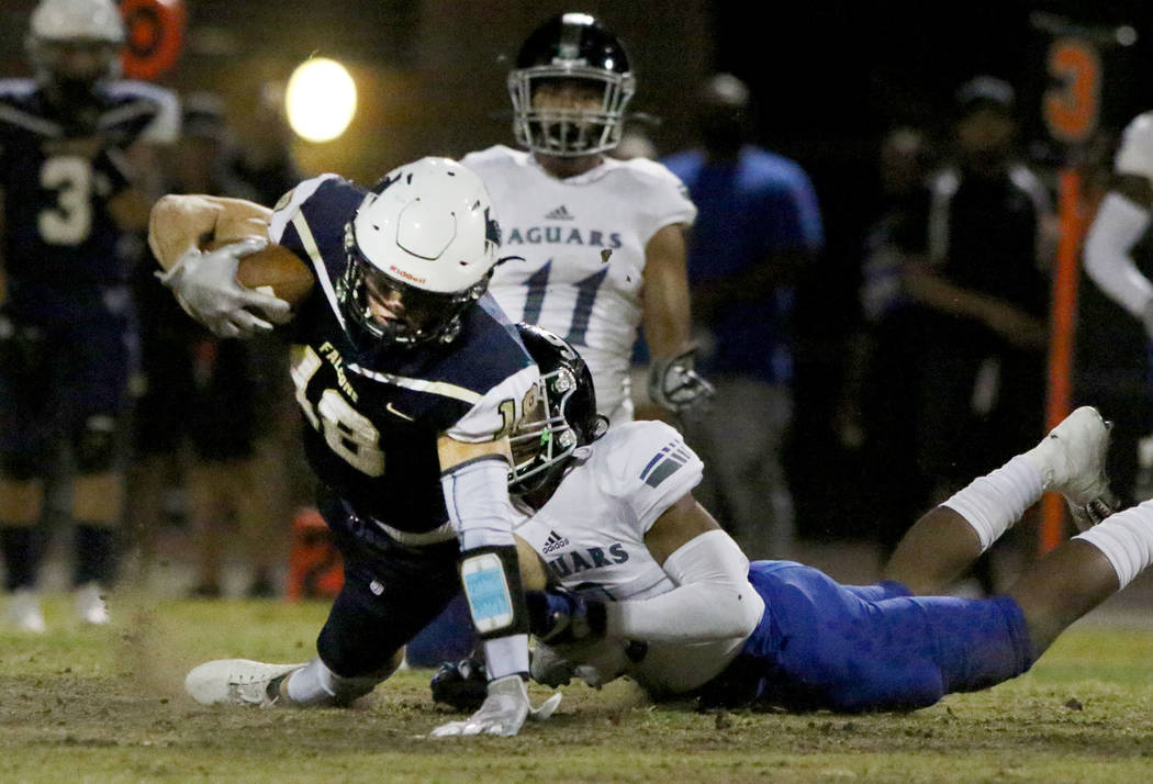 Foothill High's wide receiver Thomas Fisher-Welch (18) is take down by Desert Pines High's Core ...