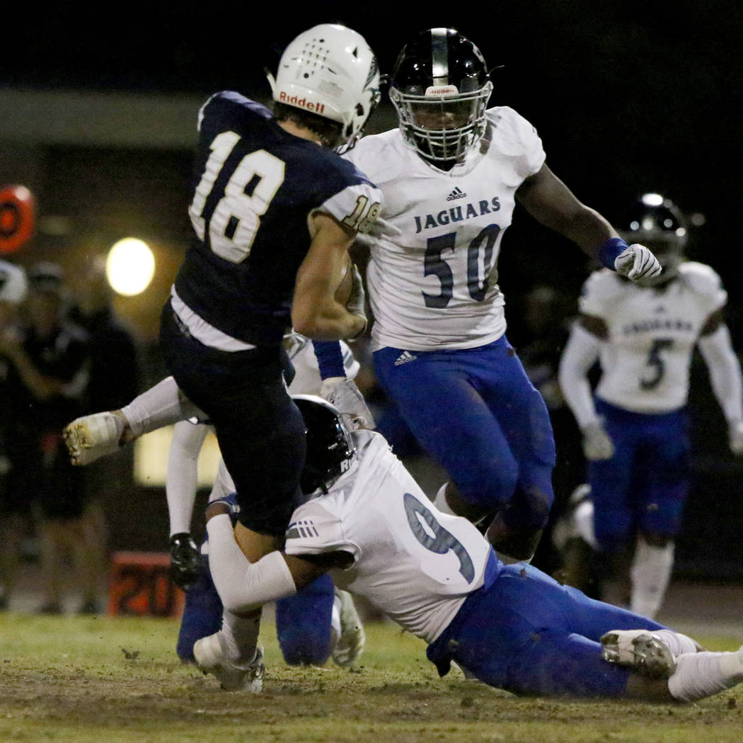 Foothill High's wide receiver Thomas Fisher-Welch (18) is tackled by Desert Pines High's Corey ...