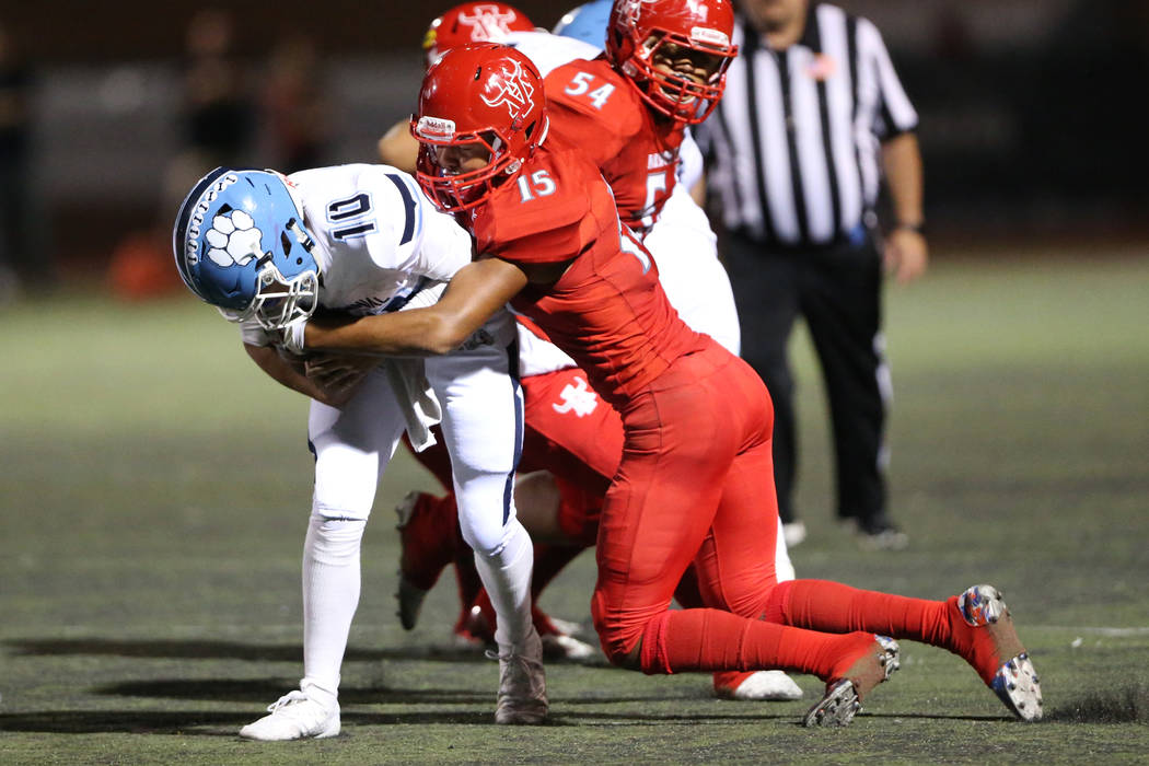 Arbor View's Anthony Jones (15) tackles Centennial's quarterback Colton Tenney (1) during the s ...