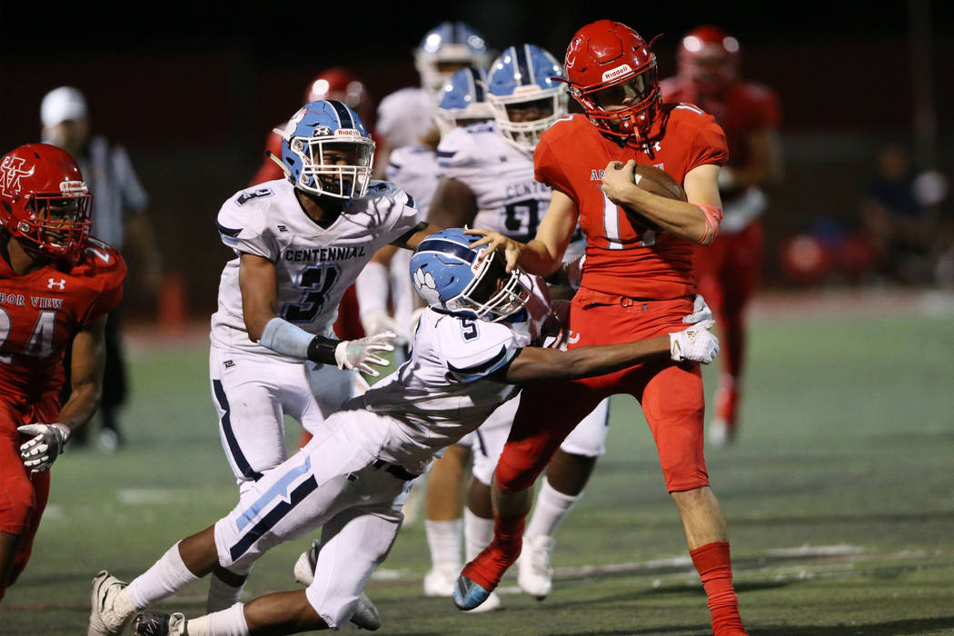 Centennial's Tyrone McCoy (5) with Donte Washington (3) tackles Arbor View's Kyle Holmes (17) d ...