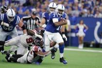 Indianapolis Colts quarterback Jacoby Brissett (7) runs out of the tackle of Atlanta Falcons de ...