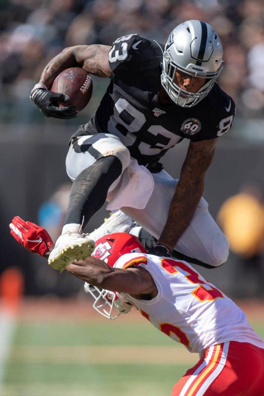 Oakland Raiders tight end Darren Waller, top, leaps over Kansas City Chiefs cornerback Charvari ...