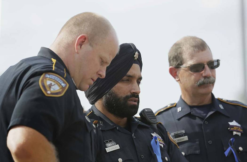 In this Aug. 30, 2015, photo, Harris County Sheriff's Deputy Sandeep Dhaliwal, center, grieves ...