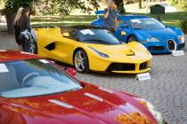 People looking at a Aston Martin One-77 Coupe (2011) in front of a Ferrari LaFerrari (2015), ye ...