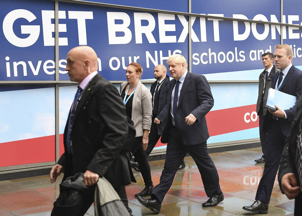 Britain's Prime Minister Boris Johnson, centre, arrives at the Conservative Party Conference in ...