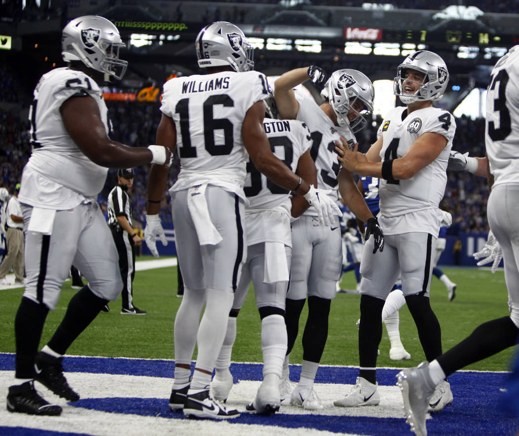 Oakland Raiders quarterback Derek Carr (4) comes in to celebrate his touchdown pass to wide rec ...