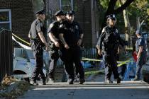 Emergency personnel walk near the scene of a fatal shooting of a New York City police officer i ...