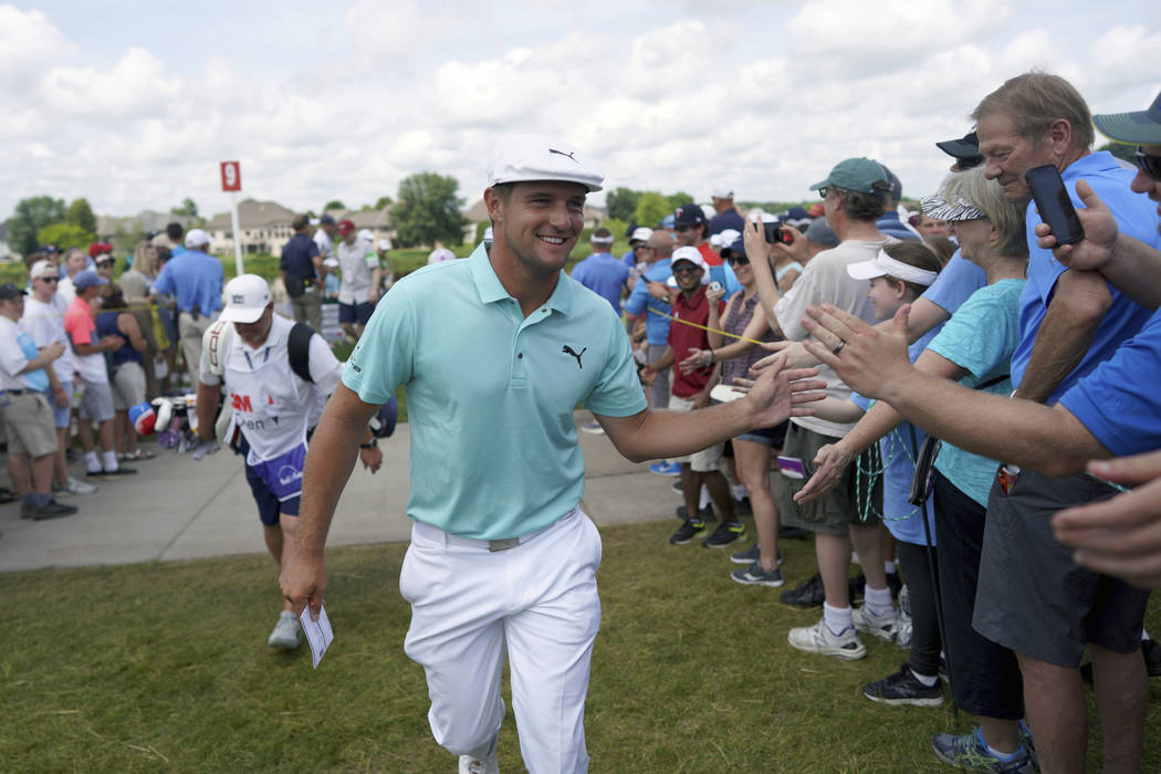 Bryson DeChambeau greets fans as he leaves the ninth hole during the second round of the 3M Ope ...