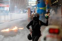 A protestor prepares to throw molotov cocktail in Hong Kong, Sunday, Sept. 29, 2019. Riot polic ...