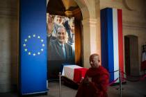 A monk walks past by the coffin of late French President Jacques Chirac, Sunday, Sept. 29, 2019 ...