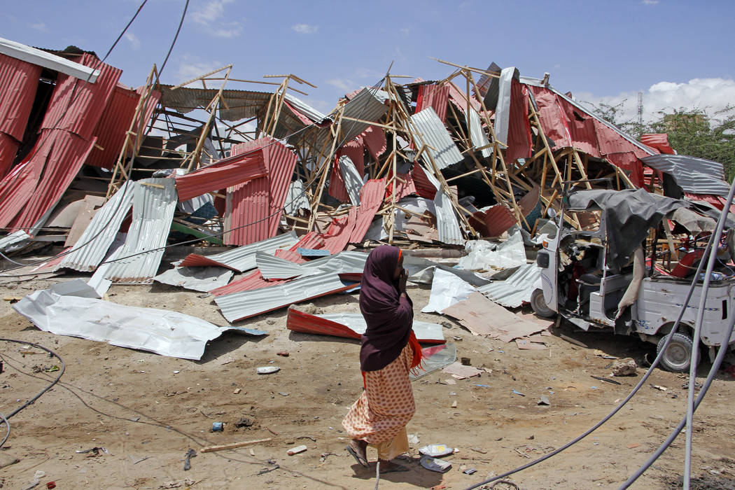 A Somali woman watch the destruction after car bomb attack on a European Union military convoy ...
