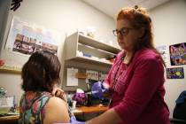 Licensed practical nurse Annmarie Homer, right, gets ready to administer a flu vaccine to regis ...