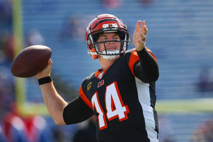 Cincinnati Bengals quarterback Andy Dalton (14) triple playas he warms up before a NFL football ...
