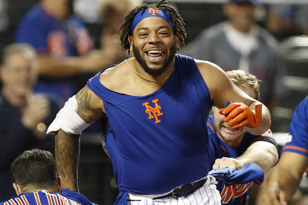 New York Mets shortstop Luis Guillorme (13) and Pete Alonso, right, tear  the jersey off teammat …