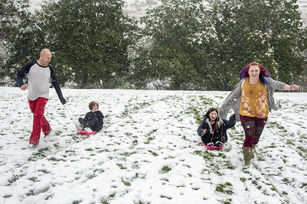 Tommy Little, from left, Cody Little, Kyndra Neal and Tanya Little use the snow accumulation to ...