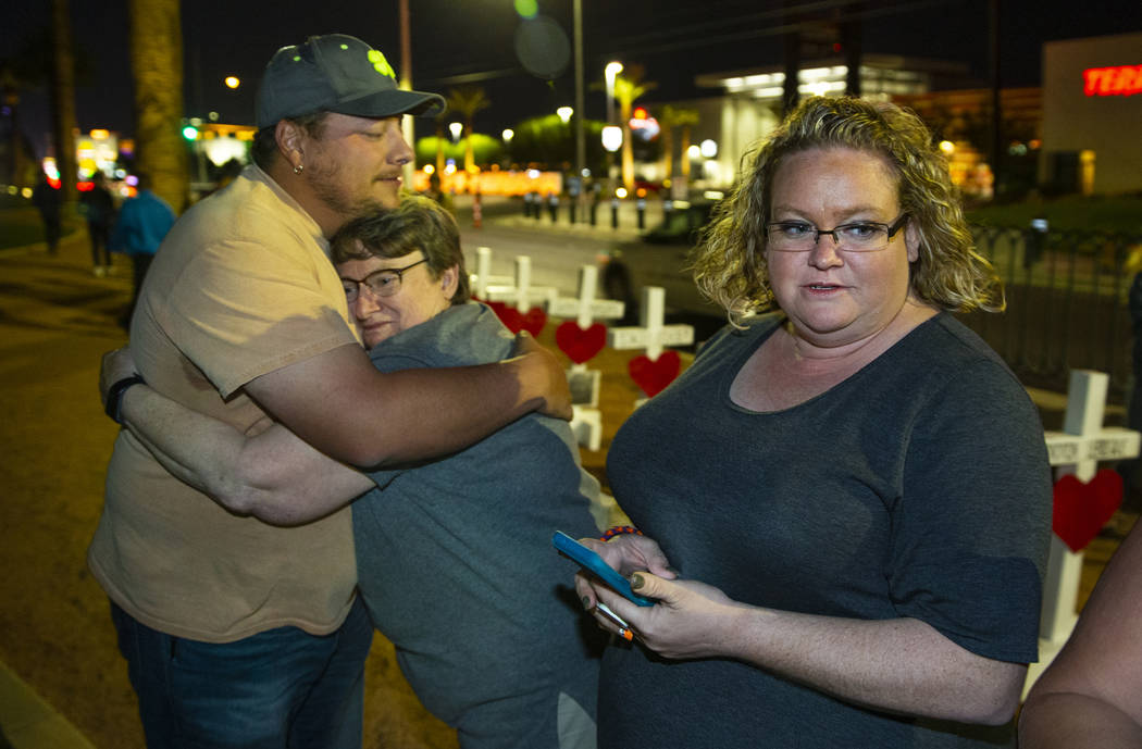 Devin Gray hugs Rosemary Semon with Heather Semon as Greg Zanis has placed 58 crosses near the ...