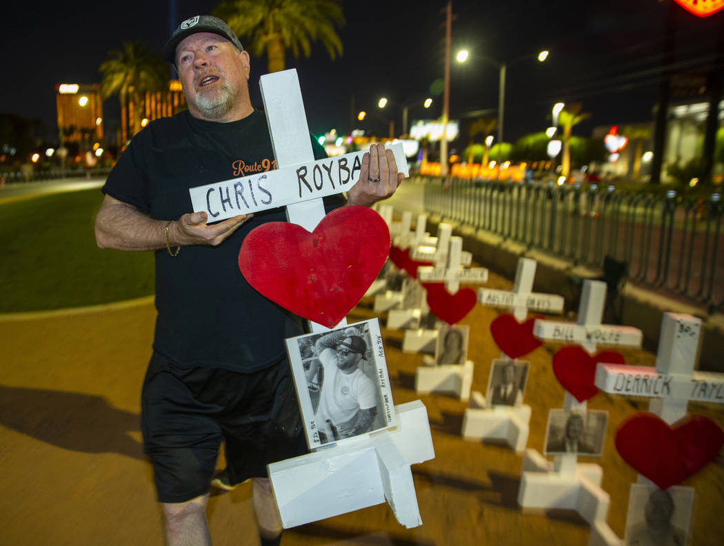 Michael Tuckman carries away a cross for Chris Roybal which they will present to his mother Deb ...