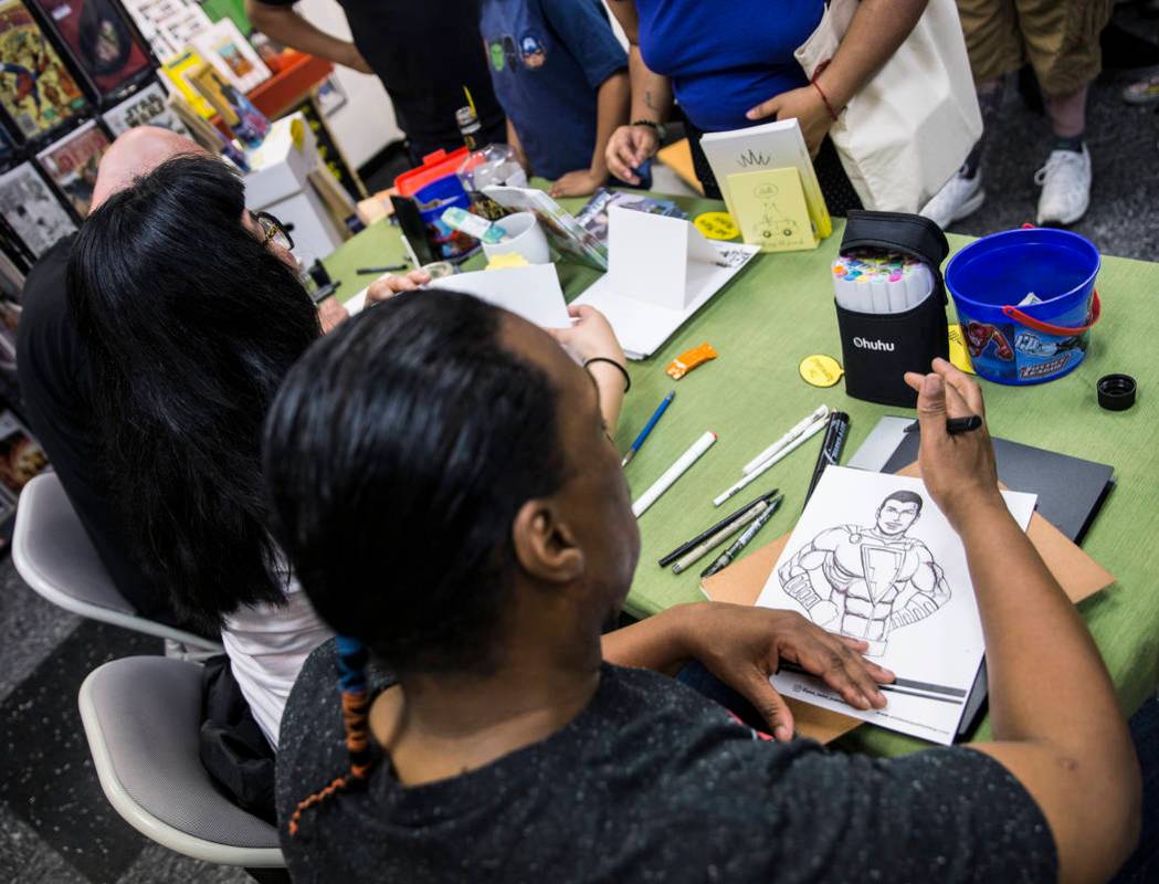 Comic book illustrator Ed Nesmith, right, draws a sketch of Shazam! during free comic book day ...