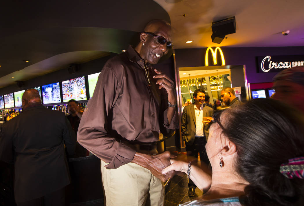 George Bell, who stands 7 feet 8 inches tall, greets onlookers while hanging out at the Longbar ...