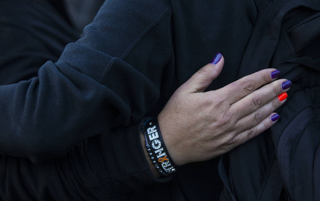 Route 91 Harvest festival shooting survivor Connie Long of Riverside, Calif., embraces a friend ...