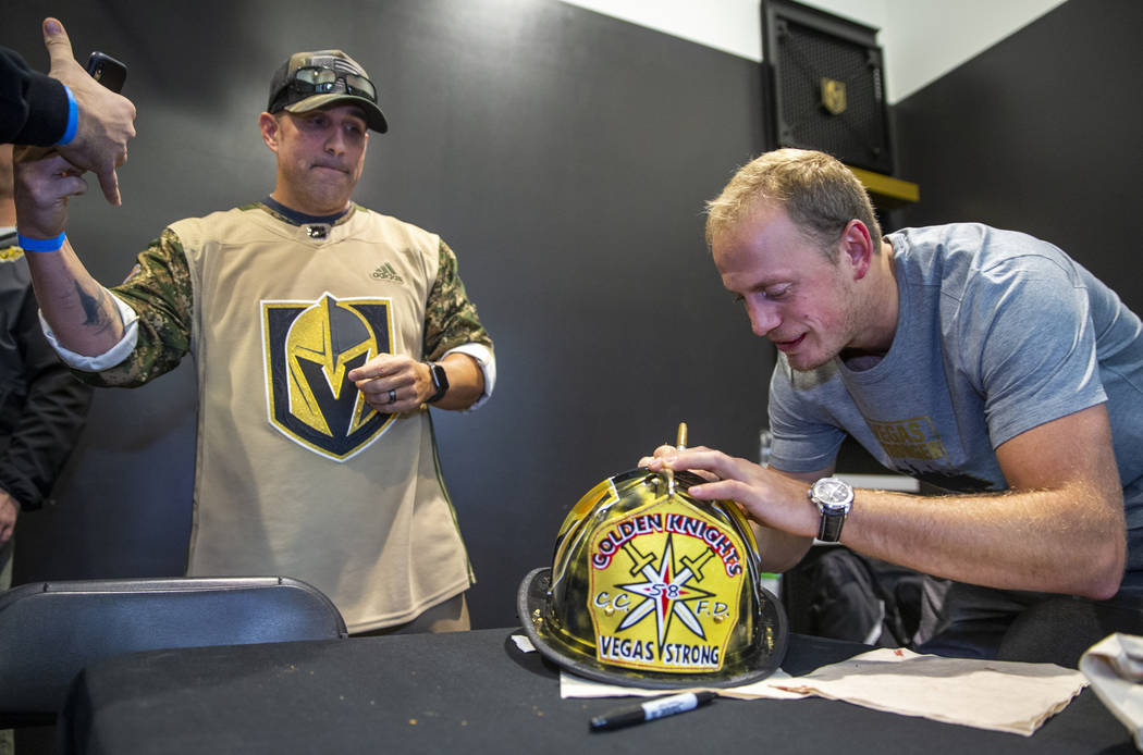 The Vegas Golden Knights Nate Schmidt, right, signs an autograph for Clark County firefighter C ...