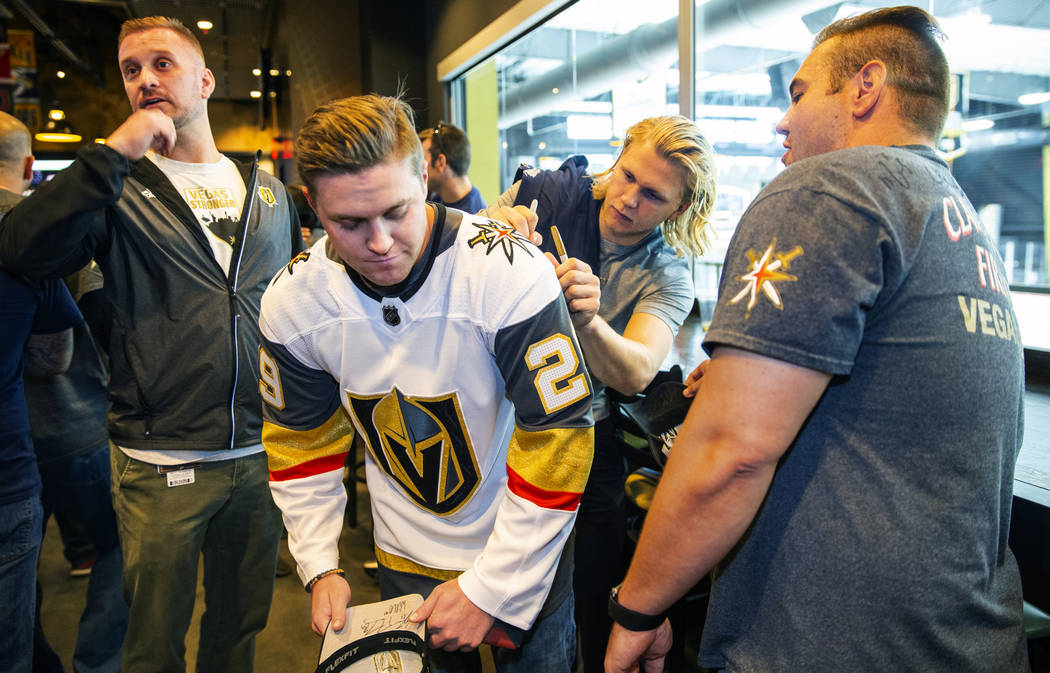 The Vegas Golden Knights William Karlsson, right, signs an autograph for Matt Sambol during a m ...