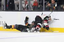 Vegas Golden Knights center Cody Glass (9) takes a fall defending Arizona Coyotes forward Nick ...